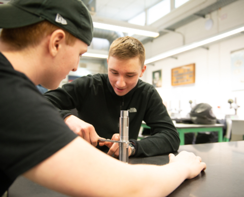 Zwei Schüler des Leistungskurses Maschinenbau führen eine Messung durch
