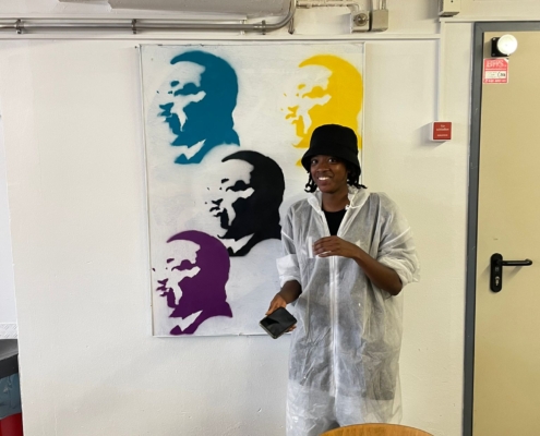 Schülerin vor ihrem Wandkunstwerk, das Martin Luther King Jr. zeigt